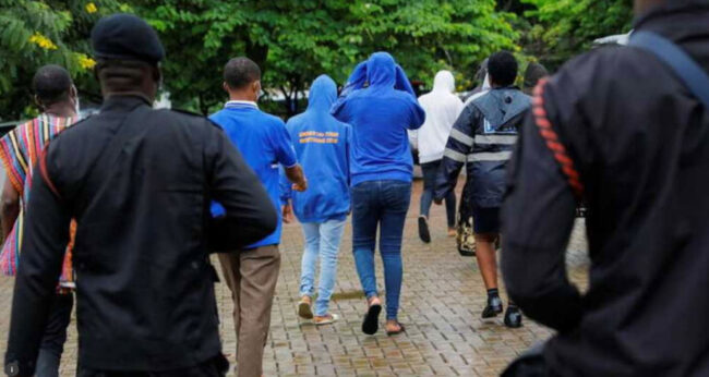 Twenty-one people, arrested in May by Ghana police on suspicion of promoting an LGBT+ agenda at an unlawful assembly, are escorted out of court after a bail hearing. They were held without trial for three weeks and then released. (Francis Kokoroko photo courtesy of Reuters)